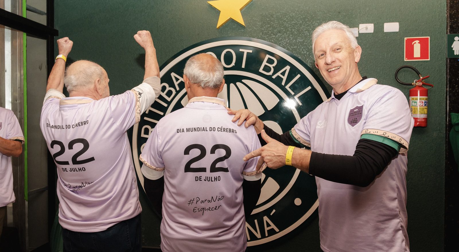Elderly participants wearing lilac World Brain Day jerseys numbered 22