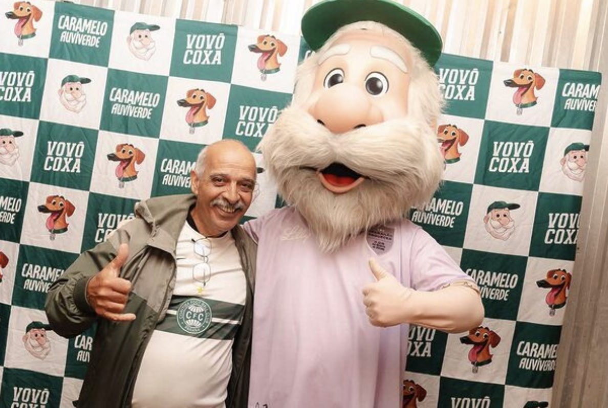 Fan posing with Vovo Coxa, the elderly grandfather mascot